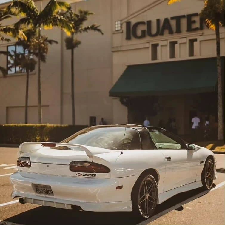 Modified white Chevy Camaro Z28 4th gen with a rear diffuser and side skirts